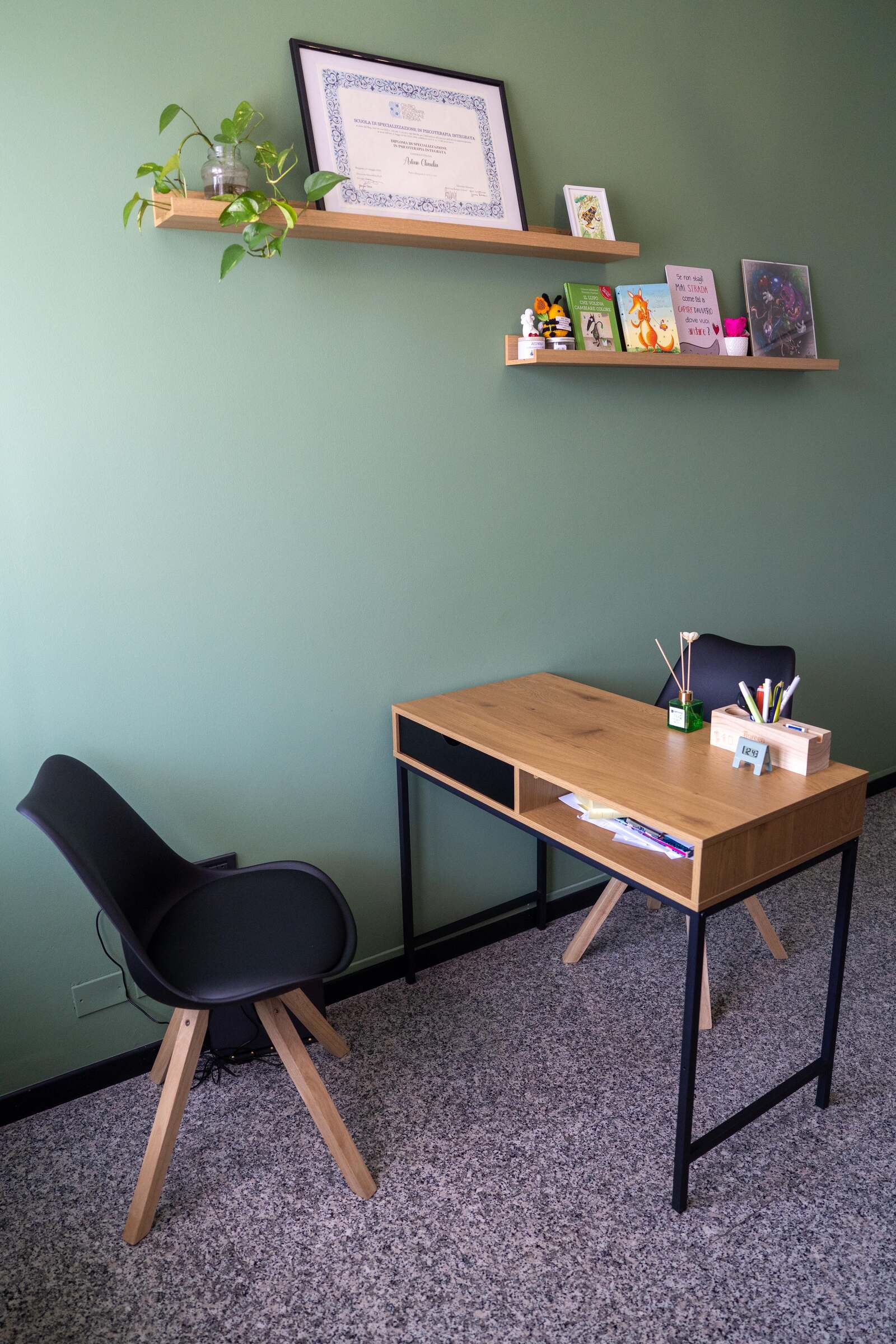 Postazione con scrivania e parete verde nello studio STP Eos a Seriate